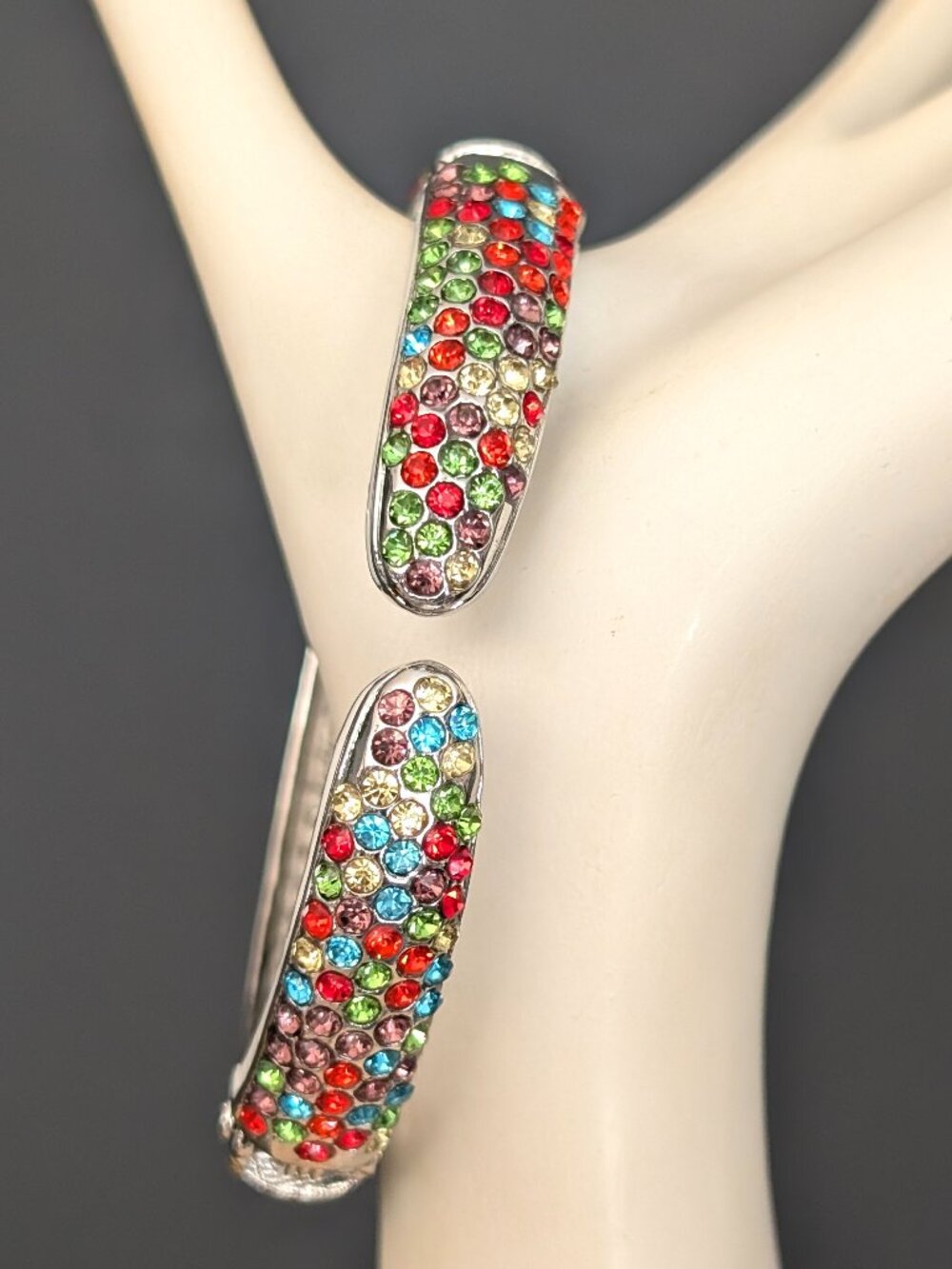 Silver tone multi crystal hinged bracelet with enamel edge